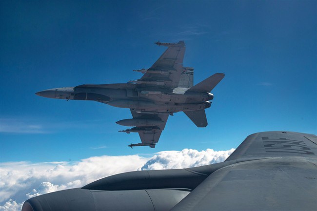 A Royal Canadian Air Force CF-18 Hornet breaks away after refueling with a KC-135 Stratotanker assigned to the 340th Expeditionary Air Refueling Squadron, Thursday,  Oct. 30, 2014 over Iraq. 